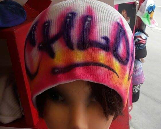 A person with a hat that has graffiti on it.