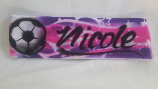A purple and pink skateboard with the name nicole written on it.