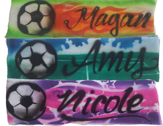 A group of four soccer bracelets with names written on them.